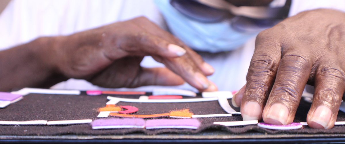 Pair of hands feeling a tactile map to learn the layout of a building. 